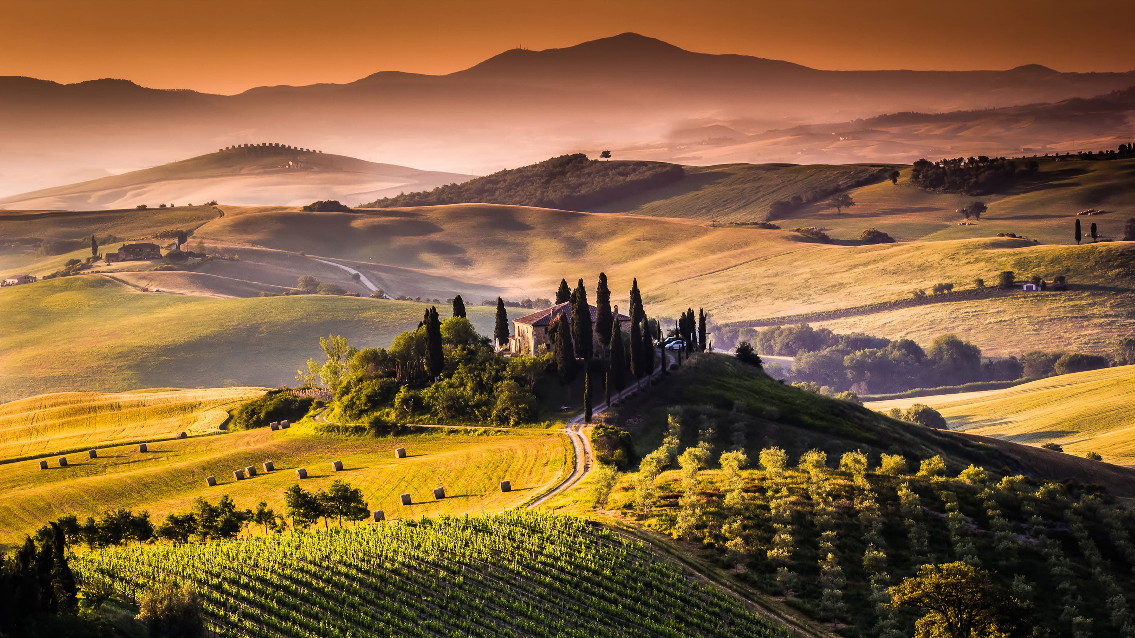 Sunlit Tuscan hills and a stone Italian home
